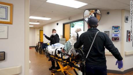 AnnieGrace Haddorff, left, and Alec Newby move a patient out of Gunnison Valley Health hospital in Colorado on November 26.
