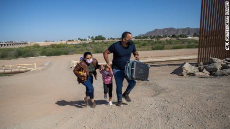A Cuban family seeking asylum in the United States crosses an open section of the border wall at the US-Mexico border in Yuma, Arizona, in May.