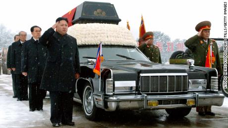 Kim Jong Un salutes his father's body during his funeral procession in Pyongyang on December 28, 2011.