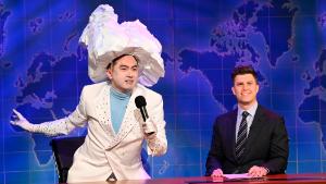 This image released by NBC shows Bowen Yang as the Iceberg that sank the Titanic, left, and anchor Colin Jost during Weekend Update on &quot;Saturday Night Live&quot; in New York on April 10, 2021. 