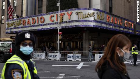 People stand in front of Radio City Music Hall after cancellations of The Rockettes performance due to Covid-19 on Friday, December 17, 2021, in New York.