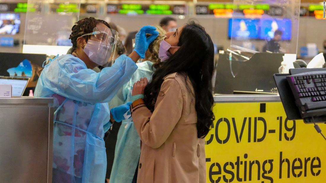 A nurse collects a nasal swab sample from a traveler at a Covid-19 testing site at the Los Angeles International Airport December 10.