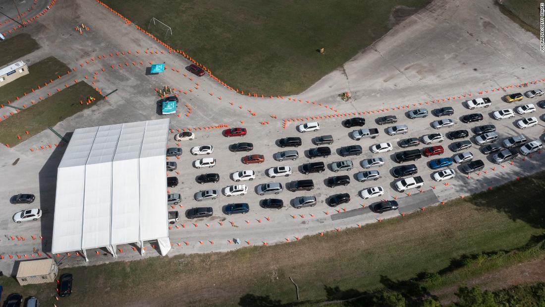 Cars line up at a drive-through Covid-19 testing site at Tropical Park December 17, in Miami.
