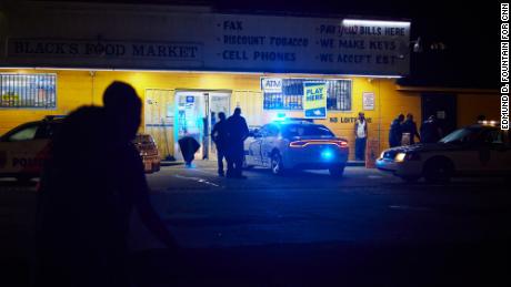 Police respond to a shooting outside a food market in Jackson. The city recently raised starting pay for new police officers to  $30,000 per year.