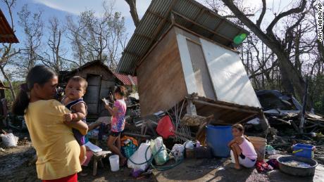 Residents stand in front of homes damaged in the wake of Typhoon Rai in Talisay, Cebu province, central Philippines, December 18, 2021. 