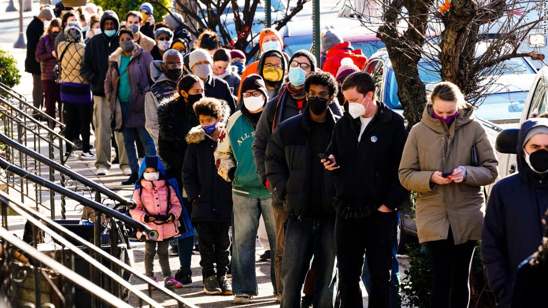 People wait in a line around the block to receive free at-home rapid Covid-19 test kits in Philadelphia on December 20.