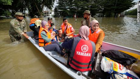 Rescuers evacuate residents on a boat in Shah Alam, Malaysia, on December 20.