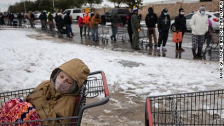 Camilla Swindle, 19, sits in a shopping cart as she and her boyfriend wait in a long line to stock up at a grocery store in Austin, Texas, on February 16, 2021. 