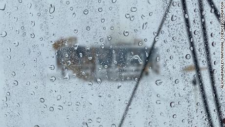 Rain droplets can be seen on a window looking out from a scientific post at the summit of Greenland in August.