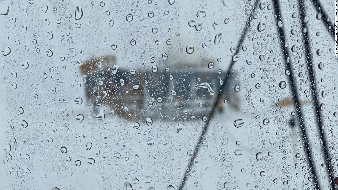 Rain droplets can be seen on a window looking out from a scientific post at the summit of Greenland in August.