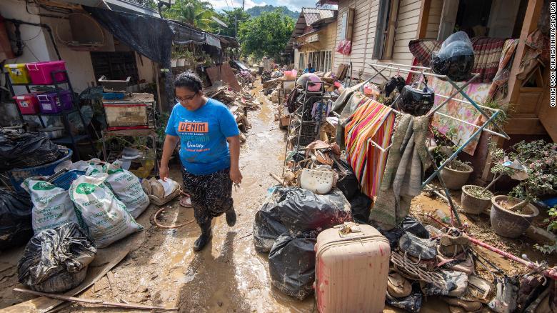 A local resident walks on a muddy path after floods hit Hulu Langat of Selangor state, Malaysia, on December 21.