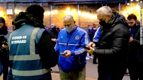 A Chelsea fan shows his Covid Pass to a Covid-19 flight attendant ahead of a match at Stamford Bridge.