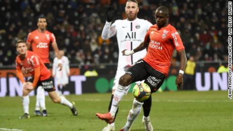 El defensor francés de Lorient, Hubulang Mendes (derecha), lucha por el balón con el defensor español del Paris Saint-Germain Sergio Ramos (centro).  Más adelante en el partido, Ramos fue expulsado por 27ª vez en su carrera.