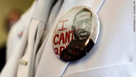 A button that reads &quot;I can&#39;t breathe,&quot; adorns the jacket of a mourner before the funeral for George Floyd on Tuesday, June 9, 2020, in Houston.