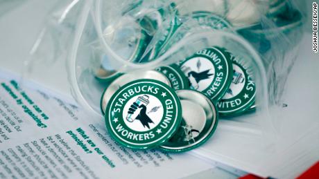 Pro-union pins sit on a table during a watch party for Starbucks&#39; employees union election, Dec. 9, 2021, in Buffalo, N.Y. 