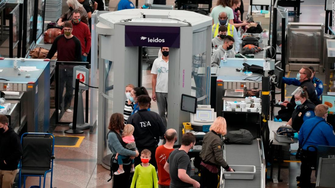 Travellers go through the south security checkpoint in the terminal of Denver International Airport Friday, Dec. 24, 2021, in Denver. More than 200 flights were cancelled by carriers out of Denver International because COVID-19 issues have created a shortage of workers.