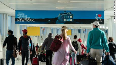 Passengers walk at John F. Kennedy International Airport during the spread of the Omicron coronavirus variant in Queens, New York City, U.S., December 26, 2021. REUTERS/Jeenah Moon