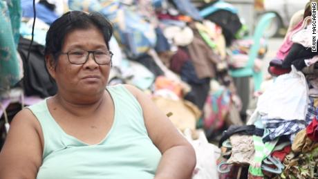 Alita Sapid sits amid her family&#39;s destroyed belongings. They lost the roof of their home in the typhoon. 