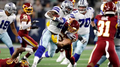ARLINGTON, TEXAS - DECEMBER 26: Ezekiel Elliott #21 of the Dallas Cowboys rushes with the ball during the first half against the Washington Football Team at AT&amp;T Stadium on December 26, 2021 in Arlington, Texas. (Photo by Wesley Hitt/Getty Images)