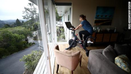 A person rides her Peloton exercise bike at home in San Anselmo, California, on April 6, 2020.