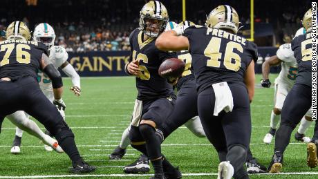O quarterback do New Orleans Saints, Ian Book (16), deu ao zagueiro Adam Prentice (46) do New Orleans Saints sua própria end zone durante o segundo tempo.