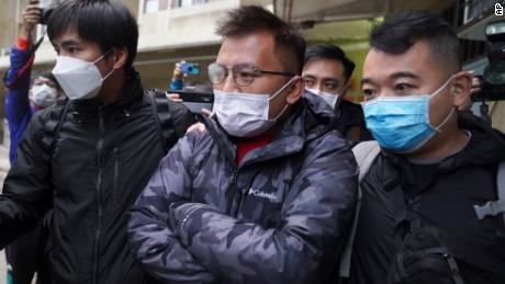 Senior editor of &quot;Stand News&quot; Ronson Chan, center, is taken away by police officers in Hong Kong, Wednesday, December 29, 2021. 