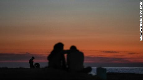 زن و شوهری در ماه نوامبر غروب خورشید را در نزدیکی صخره دریای دیدنی راوشه بیروت تماشا می کنند. 