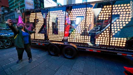 Teresa Hui poses for a selfie in front of a 2022 sign displayed in Times Square, New York, on Dec. 20, 2021. 
