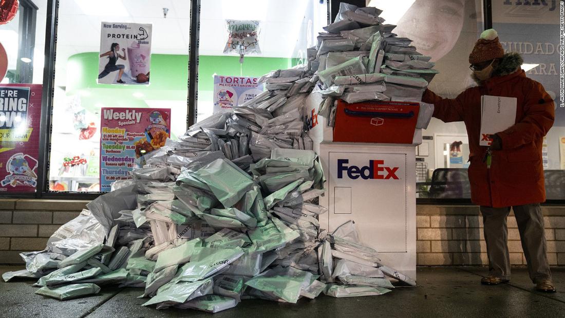 At-home Covid-19 tests, taken by Chicago Public Schools students, are piled up at a FedEx drop-off box in the neighborhood of West Elsdon on Tuesday, December 28. The school system extended the return deadline to December 30 and expanded drop-off sites.