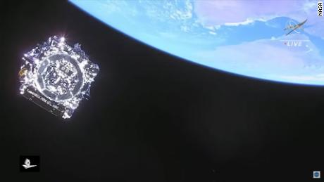 This image shows NASA's last look at the telescope after launch, captured by cameras aboard the rocket's upper stage as the telescope pulls away from it.  Earth is visible at the top right.