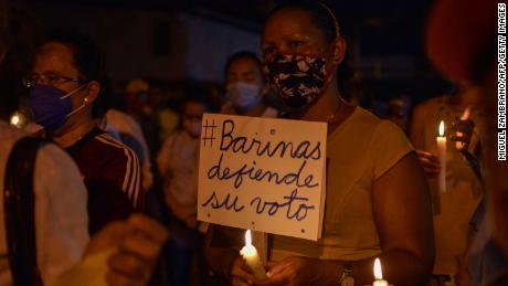 A woman holds a poster reading &quot;Barinas defends its vote&quot; during a demonstration in the city of Barinas, Venezuela, on November 28, 2021.