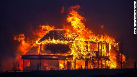 A home burns Thursday after flames swept through the Centennial Heights neighborhood of Louisville, Colorado.