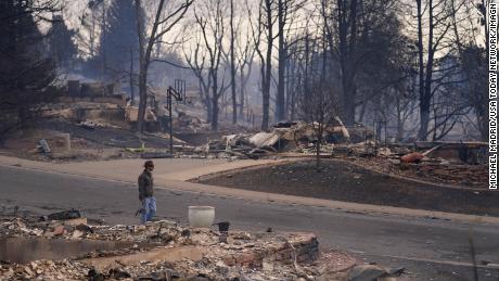 Мъж минава покрай горски пожар, който се разпространи през опустошената зона на Луисвил, Колорадо на 31 декември 2021 г. 