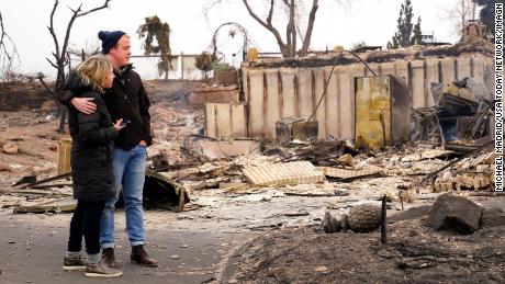 Christian Harrison and Deb Harrison examine the damage after the wildfire in Louisville, Colorado. 