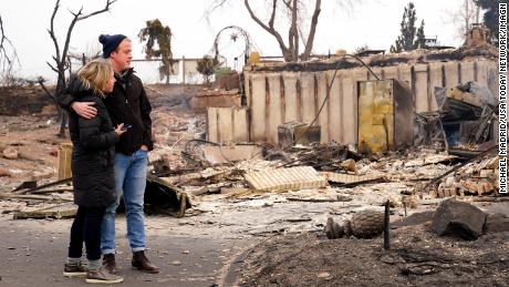 Christian Harrison and Deb Harrison examine the damage after the wildfire in Louisville, Colorado. 