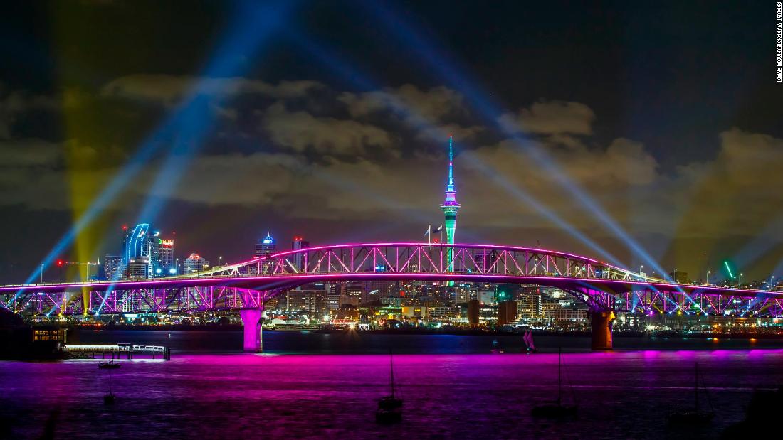 A light show from the Skytower and harbour bridge during New Year's Eve celebrations in Auckland, New Zealand. The light show named "Auckland Is Calling" replaces the normal fireworks due to government Covid-19 restrictions but signifies a welcome to visitors from New Zealand and eventually the world to the region.