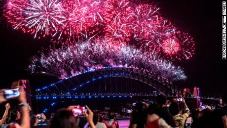 Πυροτεχνήματα φωτίζουν τον ουρανό πάνω από το λιμάνι του Σίδνεϊ καθώς πλησιάζουν τα μεσάνυχτα της 1ης Ιανουαρίου 2022 στο Σίδνεϊ της Αυστραλίας. 