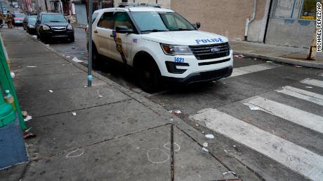 A Philadelphia police vehicle is seen parked next to chalk marks that identified spent bullet casings on Dec. 31, 2021.