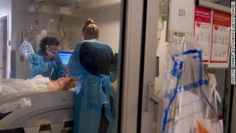 Healthcare workers treat a patient on the Covid-19 ICU floor of the University of Massachusetts (UMass) Memorial Hospital in Worcester, Massachusetts, U.S., on Monday, Dec. 27, 2021. On Friday, the Massachusetts Department of Public Health reported 10,040 new confirmed Covid cases, marking the third consecutive day that a record was set for most cases in a single day in the state. 