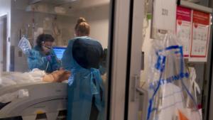 Healthcare workers treat a patient on the Covid-19 ICU floor of the University of Massachusetts (UMass) Memorial Hospital in Worcester, Massachusetts, U.S., on Monday, Dec. 27, 2021. On Friday, the Massachusetts Department of Public Health reported 10,040 new confirmed Covid cases, marking the third consecutive day that a record was set for most cases in a single day in the state. 