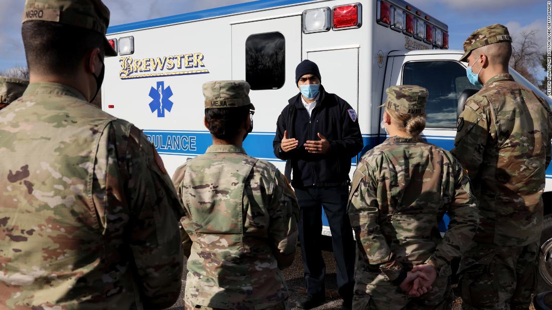 Paramedic Dan Harris, center, walks National Guard members through the ins and outs of the ambulances that they will be driving in Brockton, Massachusetts, on December 28. Guard members received clinical support and Covid-19 training from Brewster Ambulance.