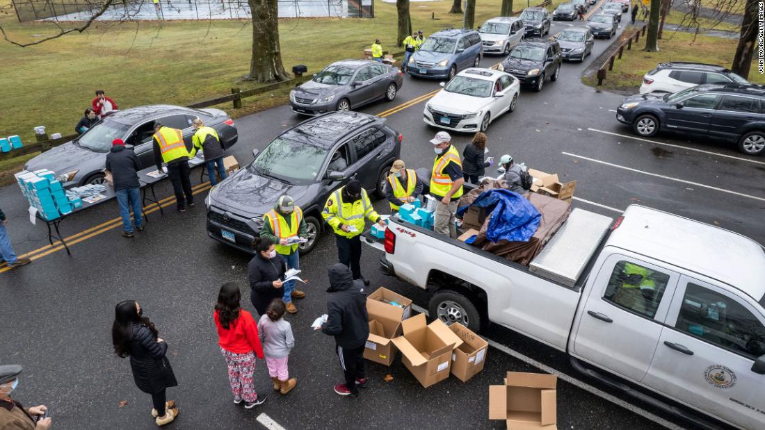 People receive free at-home Covid-19 test kits at a distribution site on January 2, 2022 in Stamford, Connecticut.