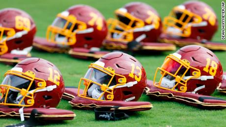 Team football helmets are lined up before practice during the Washington Football Team&#39;s training camp. 