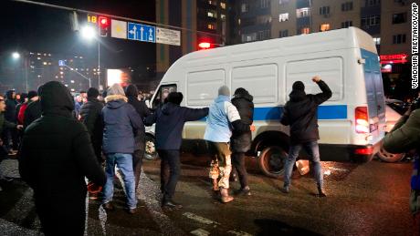 Demonstrators try to block a police bus during a protest in Almaty, Kazakhstan on January 4, 2022.
