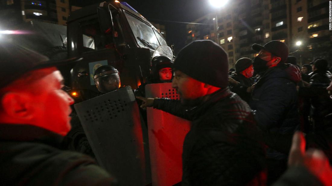 People surround police during a protest in Almaty on January 4.