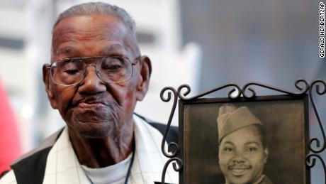 World War II veteran Lawrence Brooks holds a photo of him taken in 1943, as he passed away Wednesday at the age of 112. 