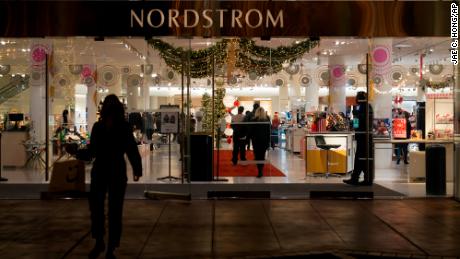 A security guard stands at the entrance to a Nordstrom store at The Grove mall in Los Angeles where a recent robbery took place. 