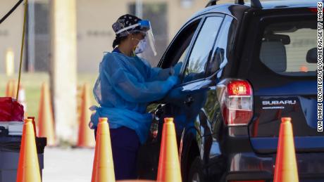 A healthcare worker administers a Covid-19 test at a drive-thru testing site at Tropical Park in Miami, on January 6.