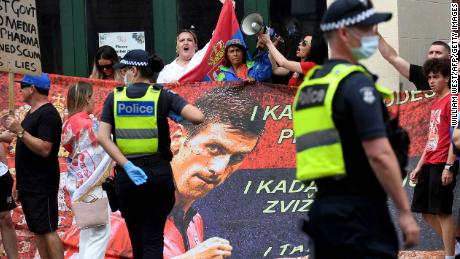 People hold placards outside the Park Hotel where 20-time grand slam champion Novak Djokovic is staying in Melbourne on January 7, 2022.