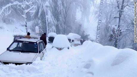 Vehicles lie trapped in a heavy snowfall-hit area in Murree, some 28 miles (45 kilometers) north of the capital of Islamabad, Pakistan, Saturday, January 8, 2022. 